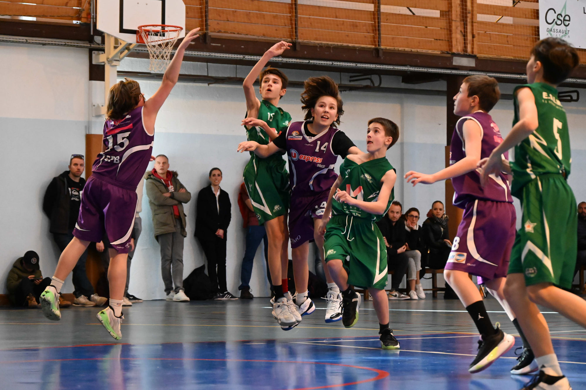 Des jeunes joueurs de l'ESEMT en maillot vert à la lutte sous le panier