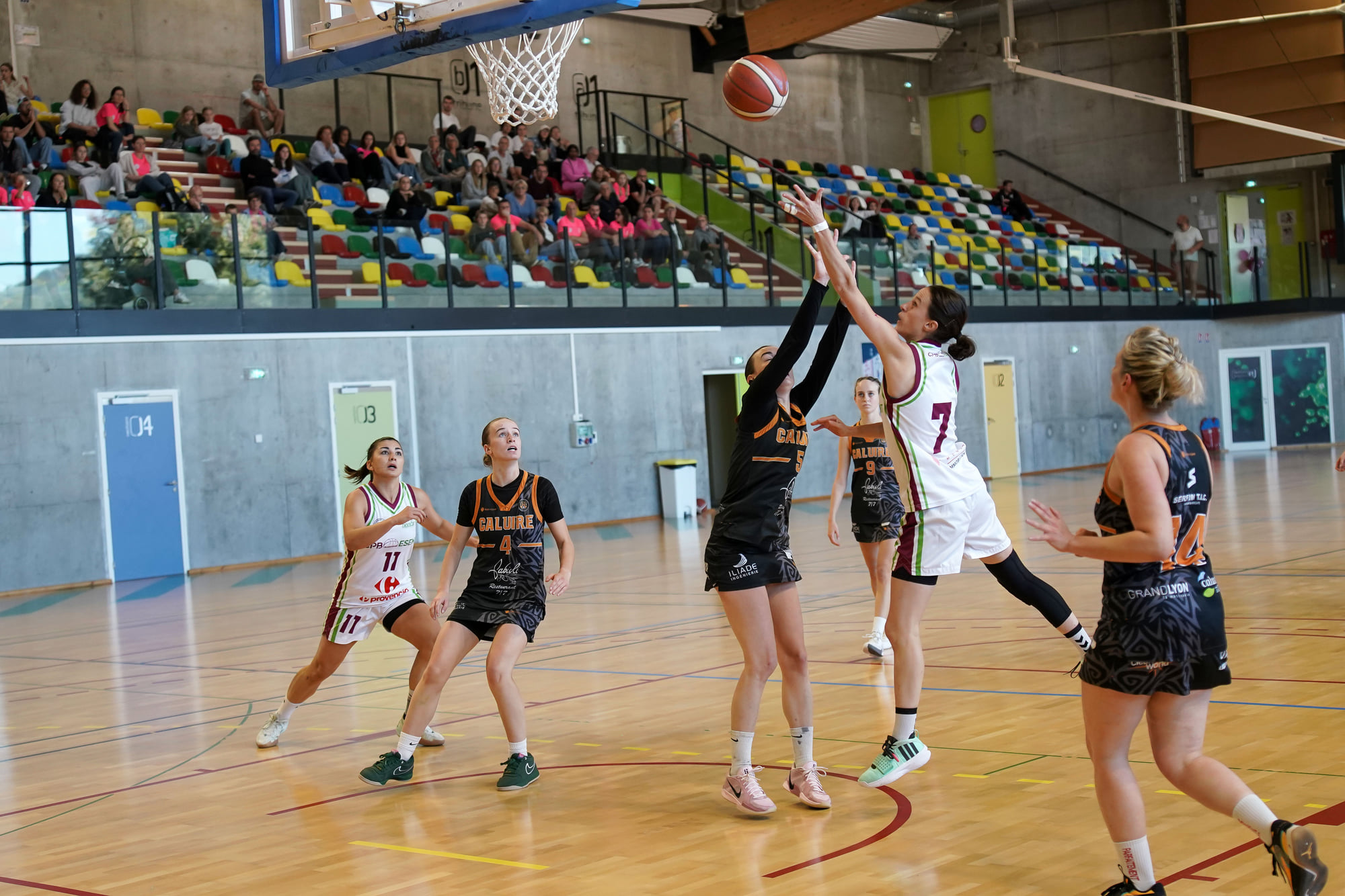 Une joueuse tente un tir en extension face à une défenseuse lors d’un match senior féminin