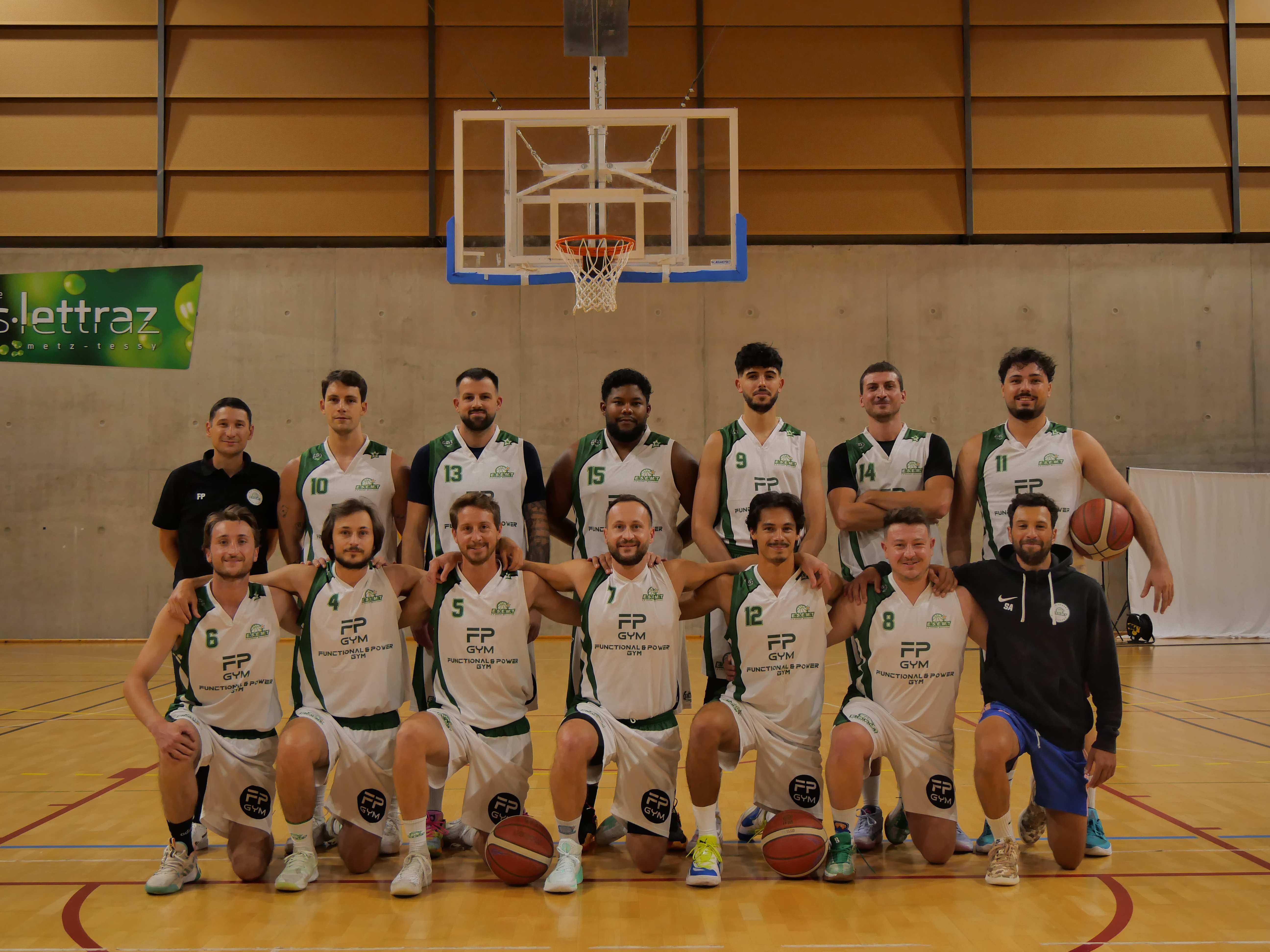 Photo d’équipe des seniors masculins de l’ESEMT en maillots blancs et verts floqués FP Gym, sous le panier
